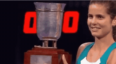 Woman Holding Trophy In Front Of 00 Sign GIF