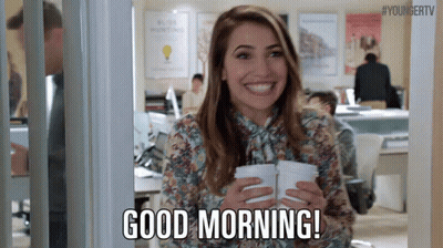 Woman Holding Two Cups Of Coffee Smiling In Office GIF