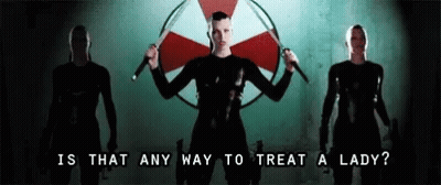 Woman Holding Two Swords In Front Of Umbrella Corp Logo GIF