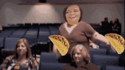 Woman Holding Two Tacos In Front Of Group GIF
