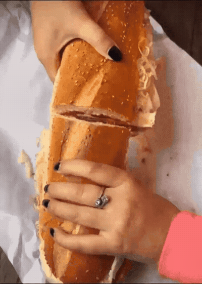 Woman Holding Very Long Sandwich With Ring GIF