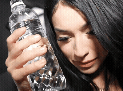 Woman Holding Water Bottle Looking Down GIF