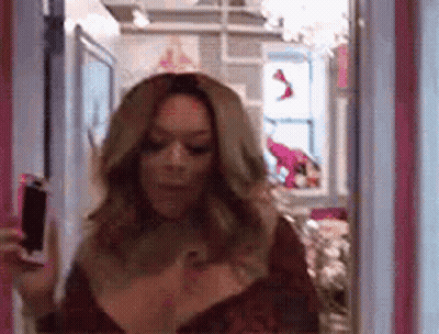 Woman Holding Wine Bottle In Front Of Mirror GIF