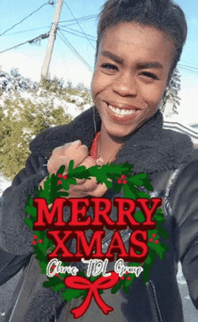 Woman Holding Wreath Saying Merry Christmas GIF