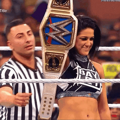 Woman Holding Wrestling Championship Belt With Bay On Top GIF
