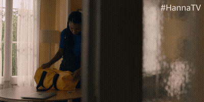 Woman Holding Yellow Duffel Bag With #Hannatv On Wall GIF