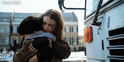 Woman Hugging Child In Front Of Bus GIF