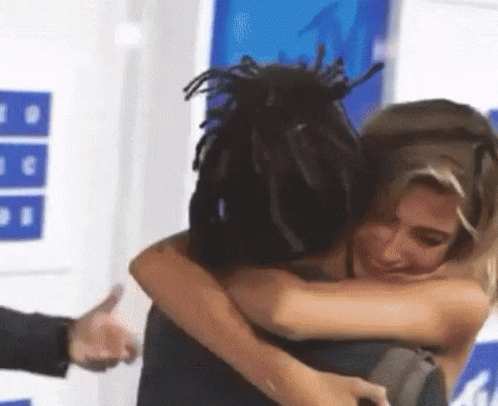 Woman Hugging Dreadlocked Man Giving Thumbs Up GIF