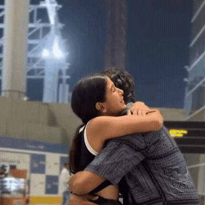 Woman Hugging Man In Front Of TC Sign GIF