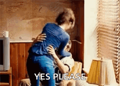 Woman Hugging Man On Couch Saying Yes Please GIF