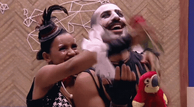 Woman Hugging Masked Man And Holding Stuffed Parrot GIF