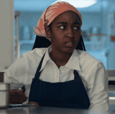 Woman In Apron And Head Scarf Looking GIF