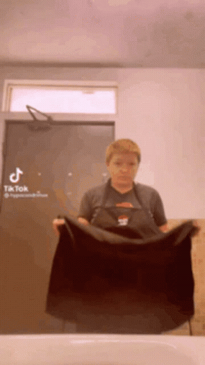 Woman in Apron Holding Black Towel