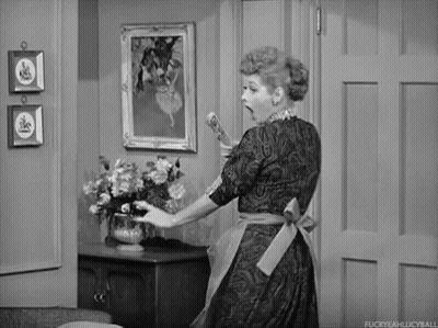 Woman In Apron Holding Vase Of Flowers GIF