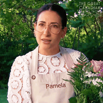 Woman In Apron Saying Pamela Holding Flowers GIF