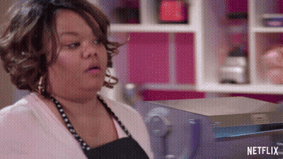 Woman In Apron Standing Before Netflix Sign GIF