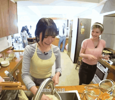 Woman In Apron Washing Dishes While Another Watches GIF