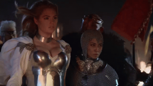 Woman In Armor Standing Next To Another Woman GIF