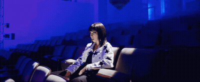 Woman In Auditorium With Purple Lights GIF