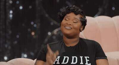 Woman In Baddie Shirt Sitting On Pink Couch GIF