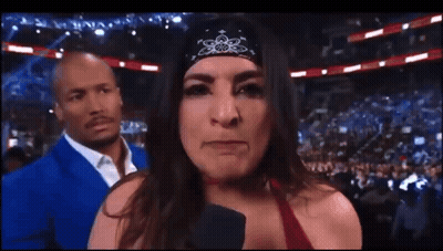Woman In Bandana Talking Into Microphone With Man In Blue Suit GIF