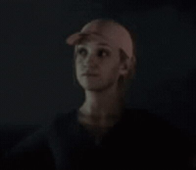 Woman In Baseball Cap Looking Up In Dark GIF