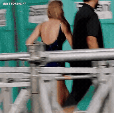 Woman In Bathing Suit Walking With Man Behind GIF
