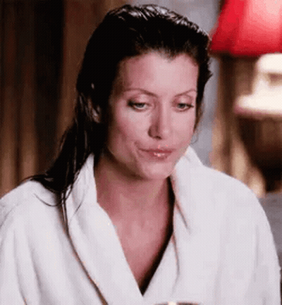 Woman In Bathrobe Making Funny Face With Wine GIF