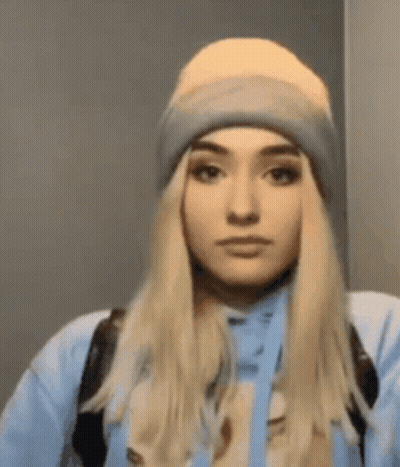 Woman In Beanie And Blue Hoodie Looking At Camera GIF