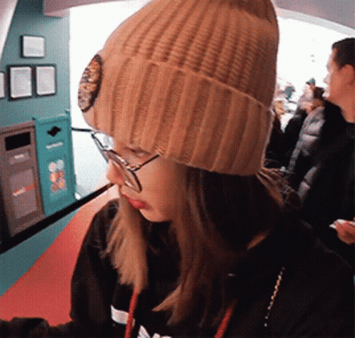 Woman In Beanie And Glasses Looking GIF