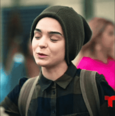 Woman In Beanie And Plaid Shirt Making Funny Face With Backpack GIF
