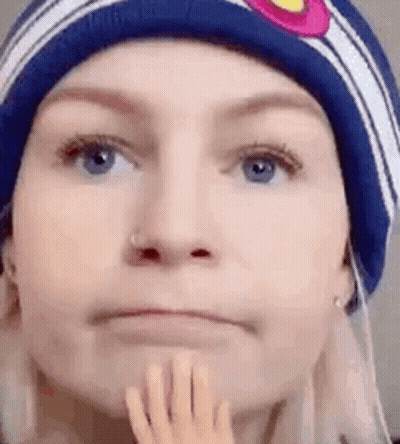 Woman In Beanie Holding Chin GIF
