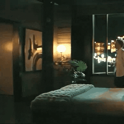 Woman In Bedroom Next To Bed And Window GIF