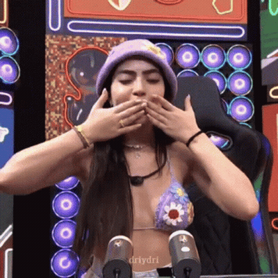 Woman In Bikini Covering Mouth With Purple Hat GIF