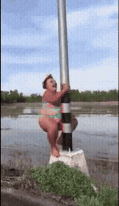 Woman In Bikini Hanging From Pole In Water GIF