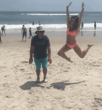 Woman In Bikini Jumping On Beach GIF