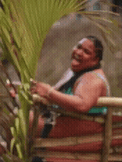 Woman In Bikini Laughing On Bamboo Fence GIF
