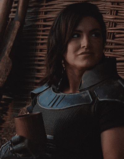 Woman In Black And Blue Armor Smiling With Cup GIF