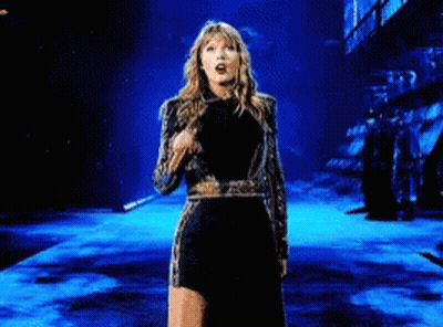 Woman In Black And Gold Dress Dancing On Stage GIF