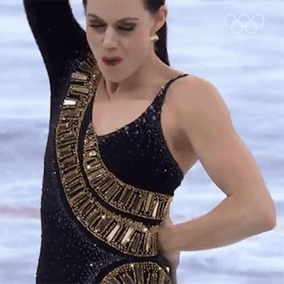 Woman In Black And Gold Dress On Ice With Olympic Rings GIF