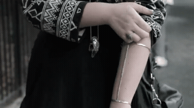 Woman In Black And White Sweater With Silver Bracelet GIF