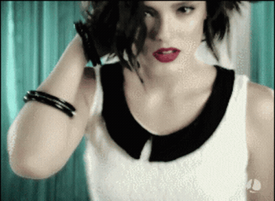 Woman In Black And White Top Holding Hair With Red Lipstick GIF