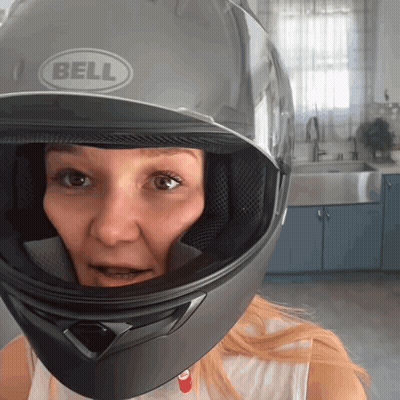 Woman In Black Bell Helmet Looks At Camera GIF
