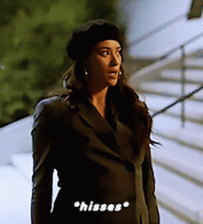 Woman In Black Beret And Jacket Saying Hisses GIF