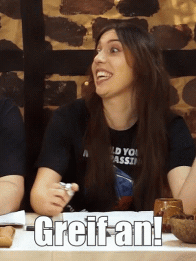 Woman In Black Bikini Top Sits At Table GIF