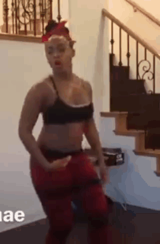 Woman In Black Bra And Red Pants Dancing Next To Stairs GIF