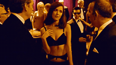 Woman In Black Bra In Crowd Of Men In Tuxedos GIF
