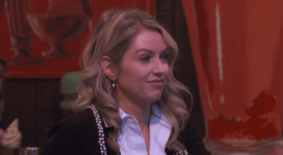 Woman In Black Cardigan Hands Folded At Counter GIF