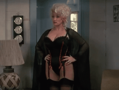 Woman In Black Corset And Stockings Next To Lamp GIF