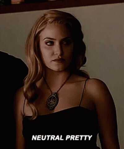 Woman In Black Dress And Necklace Says Neutral Pretty GIF